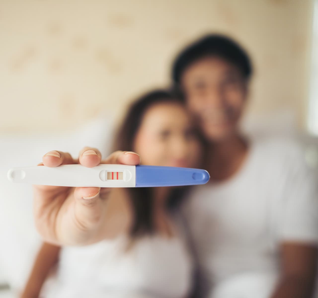 Una pareja muestra el resultado positivo de la prueba de embarazo